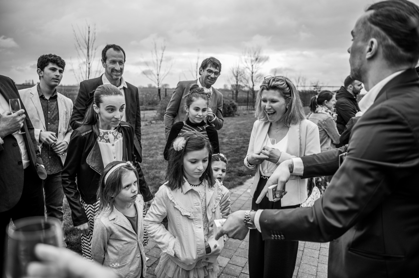 Enfants émerveillés autour de Louis Magie pendant un tour au vin d'honneur d'un mariage