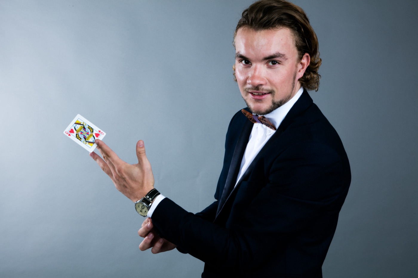 Portrait studio de Louis, magicien professionnel, présentant une carte à jouer